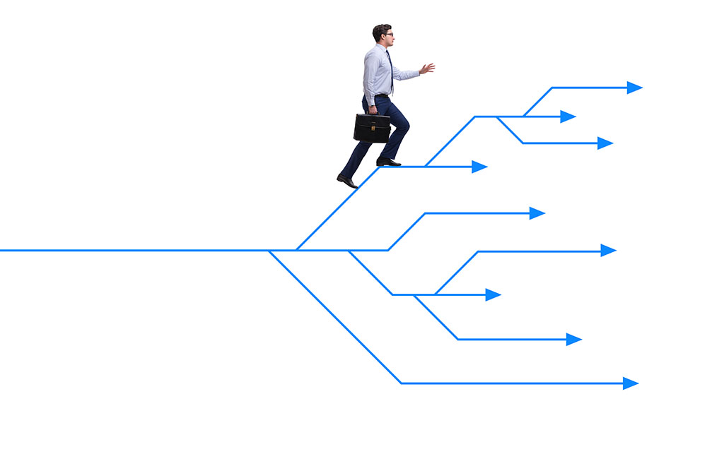 Adaptation — Be open & receptive to change when trading image. A guy wearing a white polo with tie and black trousers, carrying a black suitcase is taking steps in a complicated arrow with different directions.